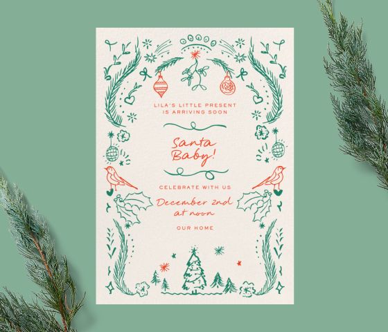 A white invitation with red and green illustrations of holiday decorations on a green backdrop with pine tree branches. 