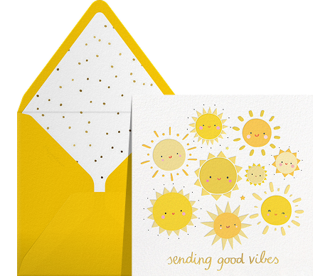 A white card with yellow suns with smiling faces and yellow text reading 'sending good vibes'. 