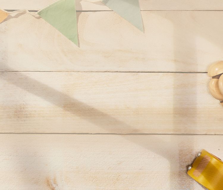 A wooden plank background framed by cloth triangles and other wooden shapes. 