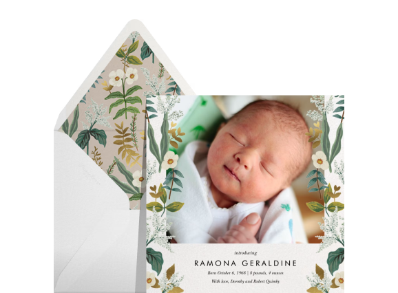 Four birth announcement cards with matching envelopes on a light blue backdrop: A photo card with a floral border, a white card with a pink ribbon border, A card with three different photos, and a black-and-white photo card with blue text and a blue ribbon border. 